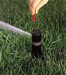 an Iriving irrigation repair team member adjusting a hunter rotary head with a rotoray key tool